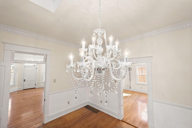 room details featuring ornamental molding, hardwood / wood-style flooring, and a notable chandelier