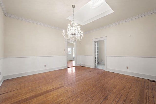 interior space featuring ornamental molding, wood-type flooring, and a notable chandelier