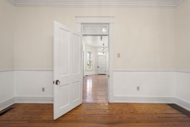 empty room featuring hardwood / wood-style floors and a notable chandelier