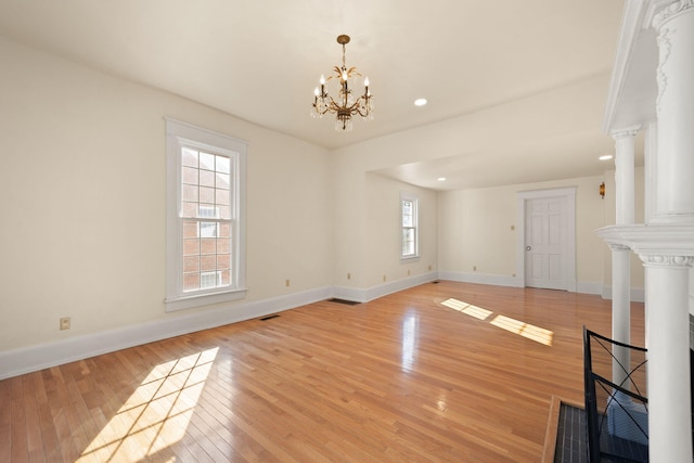 unfurnished living room featuring light hardwood / wood-style floors and an inviting chandelier