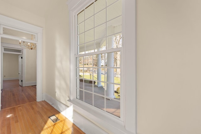 doorway to outside featuring hardwood / wood-style floors and an inviting chandelier