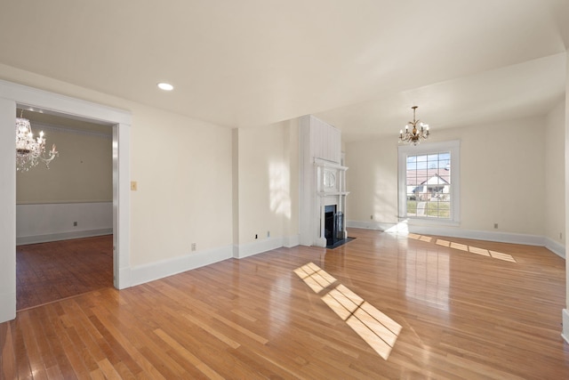 unfurnished living room with light hardwood / wood-style flooring and an inviting chandelier