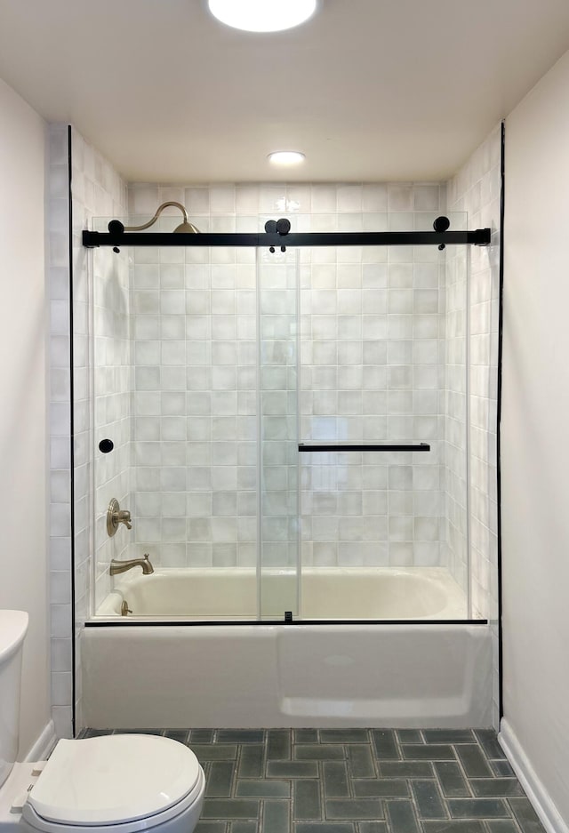 bathroom with tile patterned floors, toilet, and bath / shower combo with glass door