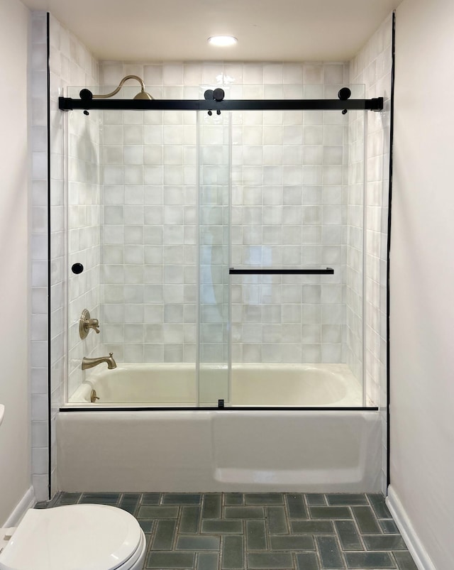 bathroom with shower / bath combination with glass door, tile patterned floors, and toilet