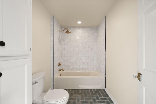 bathroom with tiled shower / bath combo and toilet