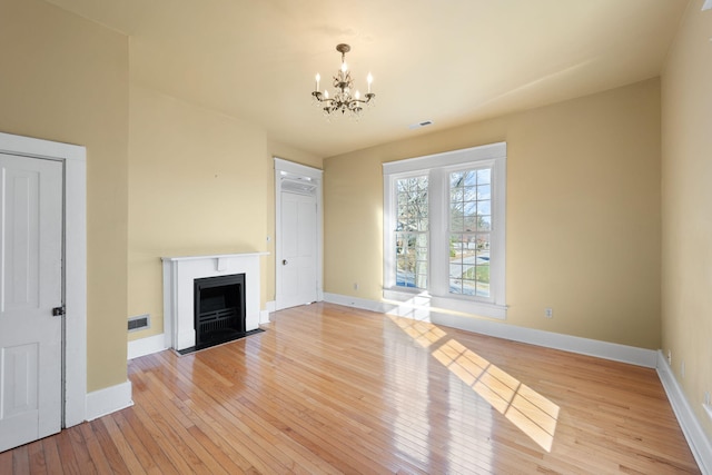 unfurnished living room featuring light hardwood / wood-style floors and a notable chandelier