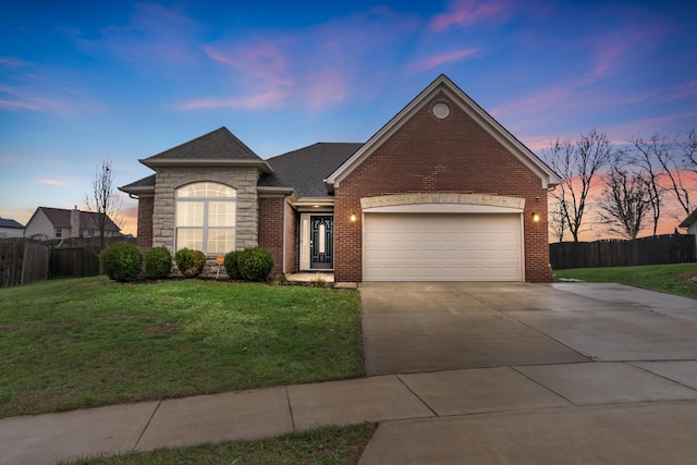 view of front of home featuring a garage, fence, a lawn, and driveway