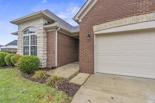 exterior space with driveway, an attached garage, stone siding, roof with shingles, and brick siding