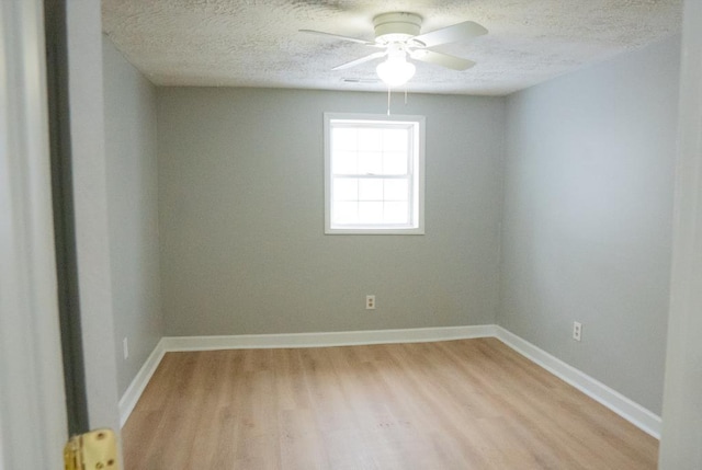 empty room with a textured ceiling, light hardwood / wood-style floors, and ceiling fan