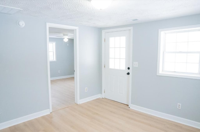 entryway with ceiling fan, a textured ceiling, and light hardwood / wood-style flooring