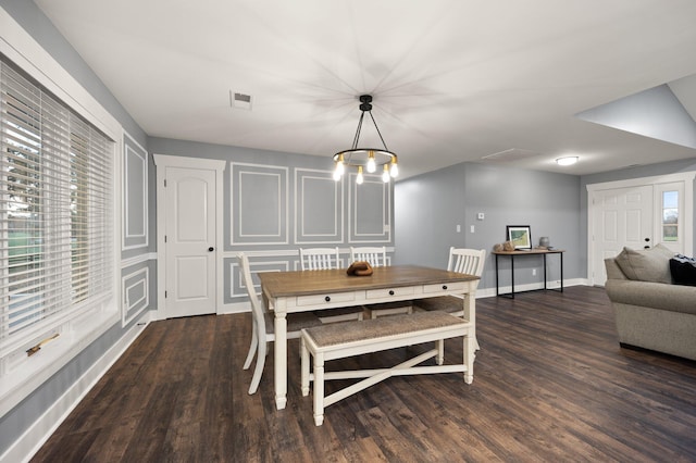 dining space featuring an inviting chandelier and dark wood-type flooring