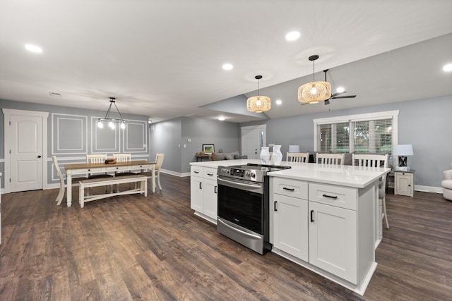 kitchen featuring dark hardwood / wood-style flooring, electric stove, decorative light fixtures, white cabinets, and a kitchen island