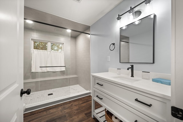 bathroom featuring a tile shower, vanity, and hardwood / wood-style flooring