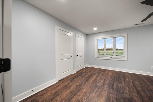 empty room featuring ceiling fan and dark hardwood / wood-style flooring