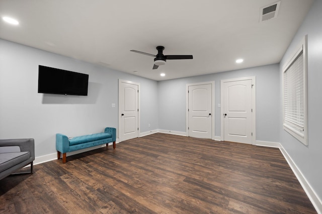 living area featuring dark hardwood / wood-style floors and ceiling fan