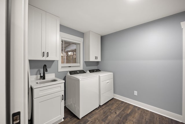 laundry area featuring washer and dryer, dark hardwood / wood-style floors, cabinets, and sink