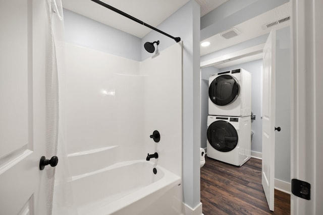 bathroom with shower / bath combination, hardwood / wood-style flooring, and stacked washer / drying machine