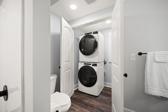 bathroom featuring hardwood / wood-style floors, toilet, and stacked washer and clothes dryer