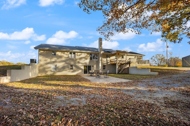 rear view of property featuring a patio and a wooden deck