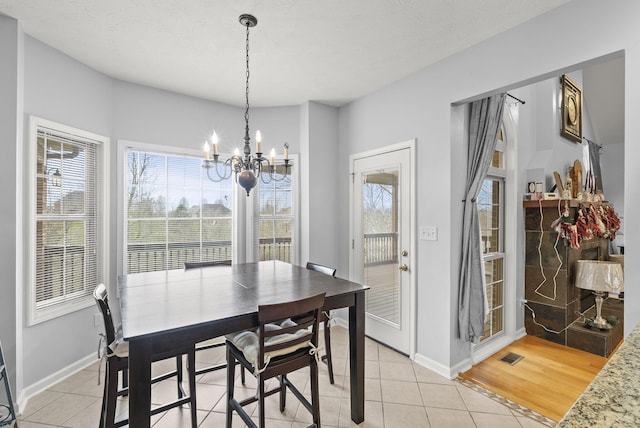 tiled dining space featuring an inviting chandelier