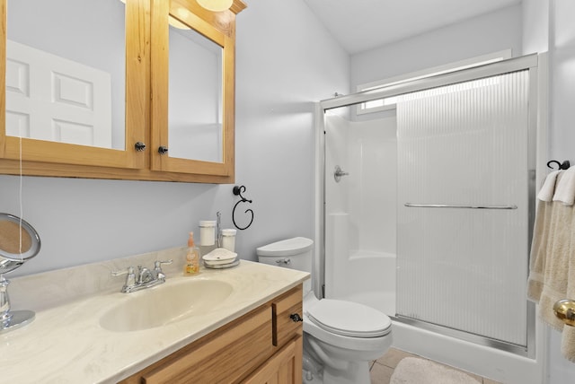 bathroom featuring tile patterned flooring, vanity, toilet, and a shower with shower door