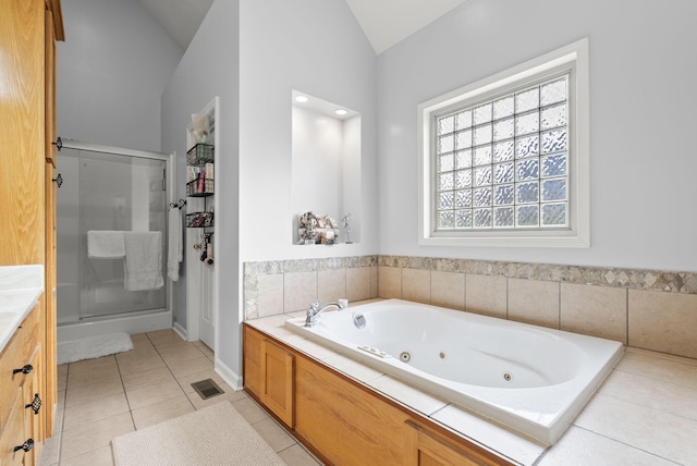 bathroom with independent shower and bath, vanity, tile patterned floors, and lofted ceiling