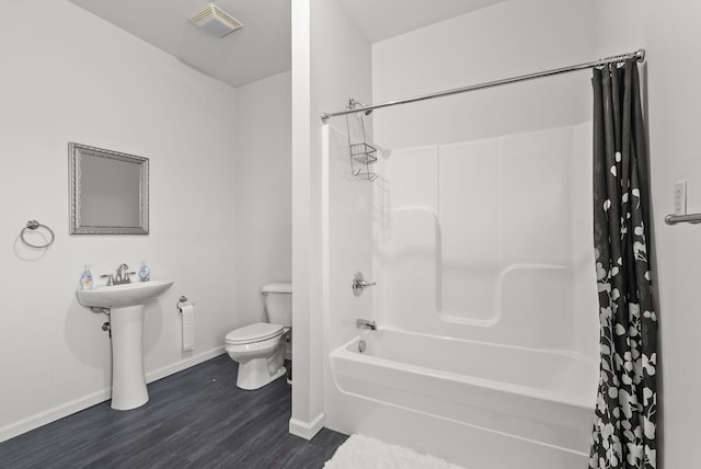 bathroom featuring shower / bath combo with shower curtain, toilet, and hardwood / wood-style flooring