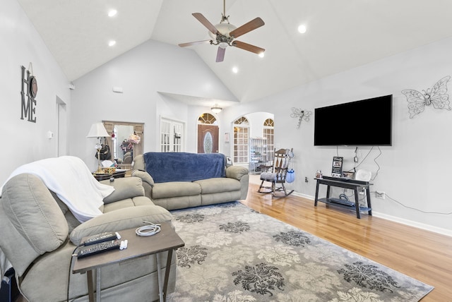 living room with hardwood / wood-style flooring, ceiling fan, high vaulted ceiling, and french doors