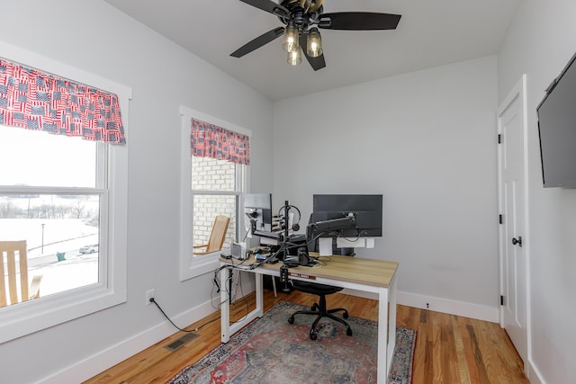 home office featuring ceiling fan, plenty of natural light, and wood-type flooring