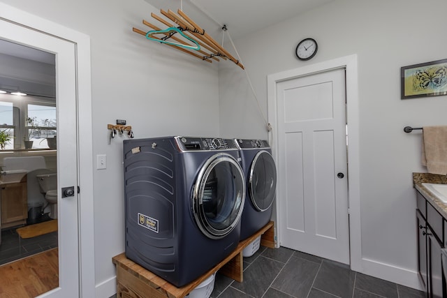 clothes washing area with separate washer and dryer and dark tile patterned floors