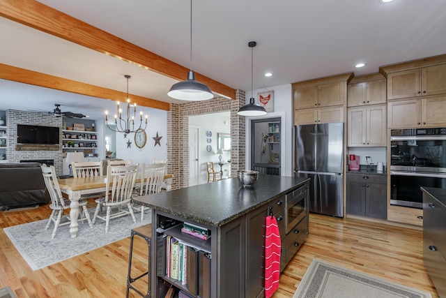 kitchen featuring brick wall, light hardwood / wood-style floors, pendant lighting, a kitchen island, and appliances with stainless steel finishes