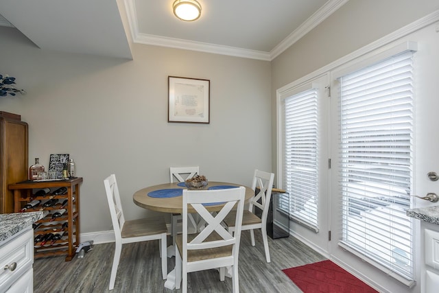 dining area featuring ornamental molding and dark wood-type flooring