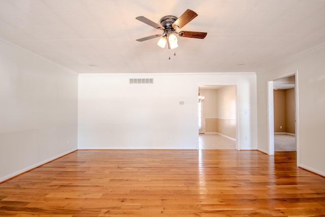 empty room with light hardwood / wood-style floors, ornamental molding, and ceiling fan