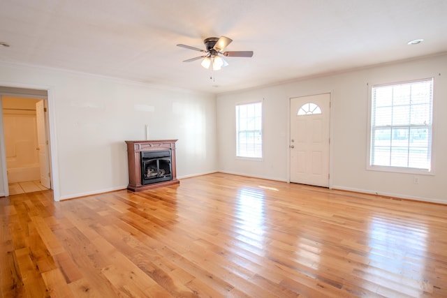 unfurnished living room featuring ceiling fan, crown molding, and light hardwood / wood-style flooring