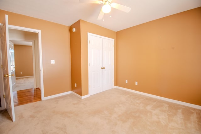 unfurnished bedroom featuring ceiling fan, a closet, and carpet