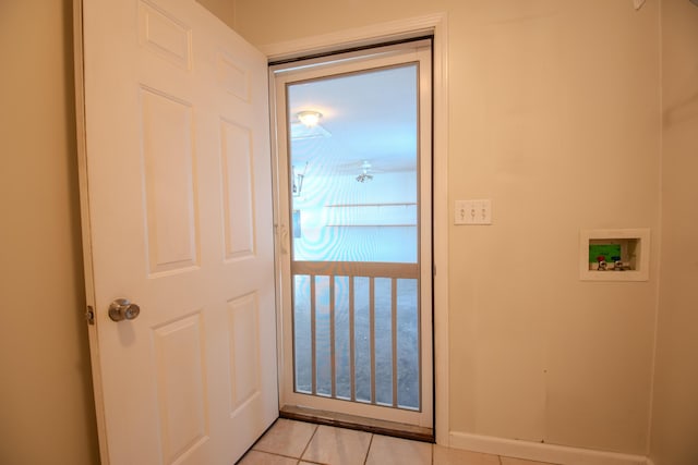 doorway to outside with light tile patterned floors