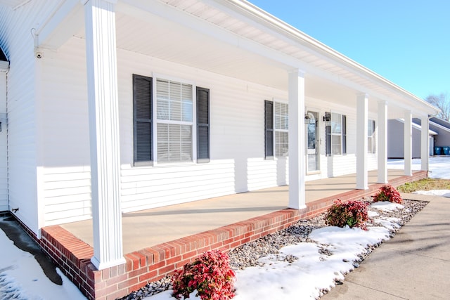 view of snowy exterior featuring covered porch