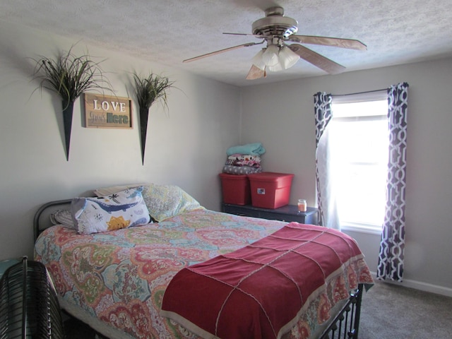 bedroom featuring carpet flooring, a textured ceiling, and ceiling fan