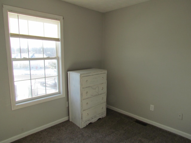 unfurnished bedroom featuring dark carpet