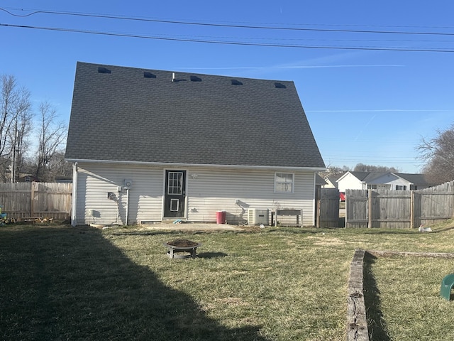 back of property featuring a lawn and an outdoor fire pit