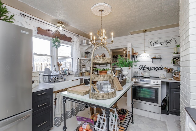 kitchen with pendant lighting, stainless steel appliances, an inviting chandelier, and a textured ceiling