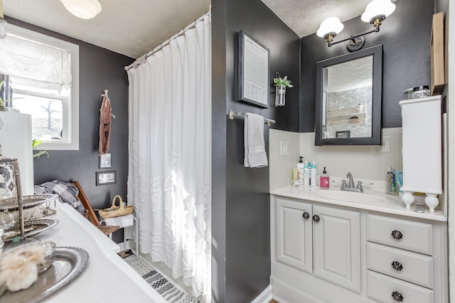 bathroom with a shower with curtain, vanity, a textured ceiling, and backsplash