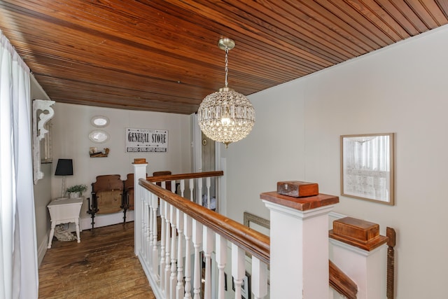 corridor featuring hardwood / wood-style flooring, wood ceiling, and a chandelier