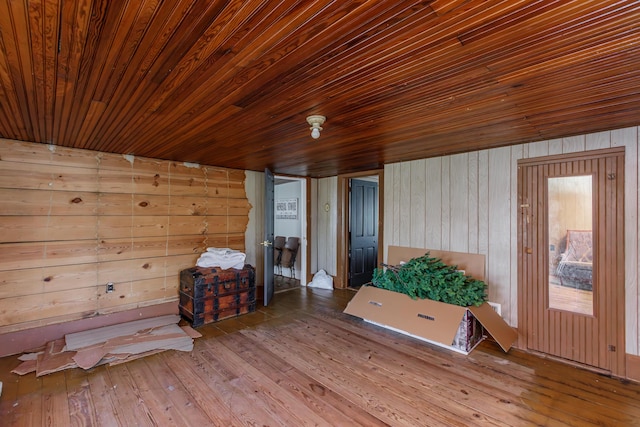 interior space featuring wood-type flooring, wooden ceiling, and wooden walls