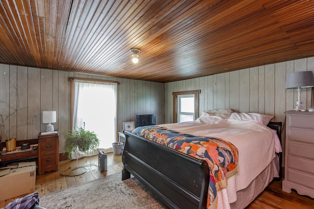 bedroom featuring hardwood / wood-style flooring, wood ceiling, and multiple windows