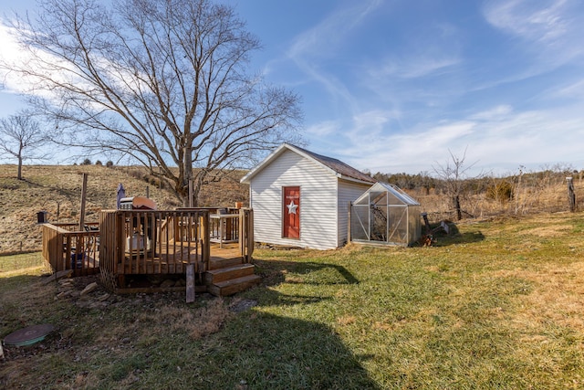 view of yard with an outdoor structure, a rural view, and a deck