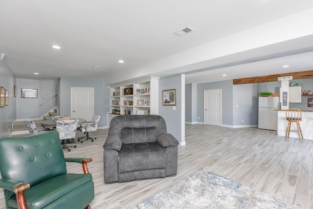 living room with built in features and light hardwood / wood-style flooring