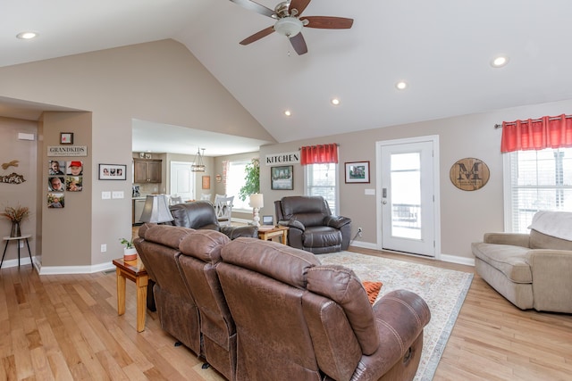 living room featuring ceiling fan, light wood-type flooring, and high vaulted ceiling