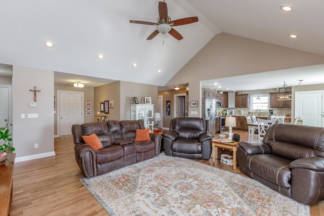 living room with ceiling fan, light hardwood / wood-style floors, and high vaulted ceiling