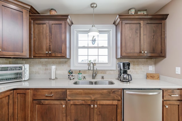 kitchen featuring backsplash, sink, hanging light fixtures, and stainless steel dishwasher